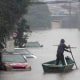 A man rows a boat on a flooded street in Brazil