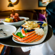 A waitress carries a tray a lobster kettle and a crab trio dish at a Red Lobster restaurant.
