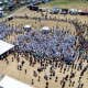 A drone overhead image of over 700 people gathered on a field