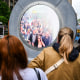 People interact with a massive circular livestream video "portal"