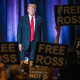 People hold up signs reading "Free Ross" as Donald Trump arrives.