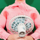 Photo of woman sweating and holding a fan 