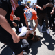 A supporter of Israel and a pro-Palestinian protester fight on the ground