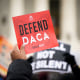 Immigration rights activists with a sign that reads 'DEFEND DACA.'