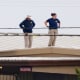 Two FBI investigators scan on Sunday the roof of AGR International Inc, the building adjacent to the Butler Fairgrounds, from which alleged shooter Matthew Thomas Crooks fired at Donald Trump the previous day in Butler, Pa.