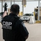 Customs and Border Protection agents direct vehicles.