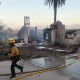 Firefighters clean up as the Edgehill Fire destroyed several homes and vehicles in San Bernardino, Calif., Aug. 5, 2024. 