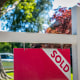 A "Sold" sign in front of a home.