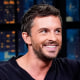 Jonathan Bailey sits and smiles