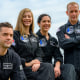 The four crew members smiling as they pose for a photo