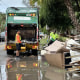 Waste Management employees pick up storm debris