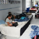 People sleep on mattresses in a school hallway