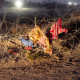 Discarded blankets and clothing hang caught in razor wire outside at night