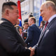 Kim Jong Un shakes hands with Vladimir Putin.