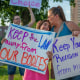 Eleven-year-old Giuliana Cangelosi, left, and her mother Nichole Cangelosi share a moment together while attending a protest opposing the Supreme Court's ruling overturning federal protections for abortion rights June 24, 2022, in Mill Creek Park at Country Club Plaza in Kansas City, Missouri. 