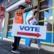 A poll worker directs an early voter to a polling station