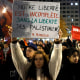 Protestors hold signs during a demonstration against the soccer match between France and Israel in Aubervilliers, France