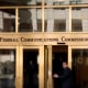 A man walks into the Federal Communications Commission (FCC) headquarters