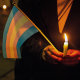 A protester seen holding a candle and a transgender flag