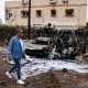 A resident walks past charred cars  in Petah Tikva, Israel, near Tel Aviv, on Nov. 24, 2024, after rockets were fired from Lebanon.