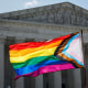 A person waves LGBTQ flag.