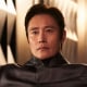 Lee Byung-hun sits on a sofa chair