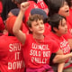 Protestors sit on the ground and link arms wearing shirts that say "Council Sold Out Philly"