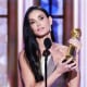 Demi Moore holds an award on stage