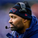 Jerod Mayo looks across the football field from the sidelines