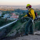 A Firefighter sprays water over a hillside