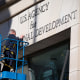 A worker removes the U.S. Agency for International Development sign on their headquarters on Feb. 7, 2025 in Washington.
