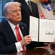 President Donald Trump signs an executive order in the Oval Office at the White House on Feb. 25, 2025. 