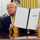 President Donald Trump holds up an executive order on March 7, 2025 in the Oval Office. 