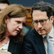 Rebecca Kelly Slaughter, left, chats with Alvaro Bedoya, both are seating inside a building