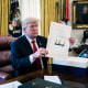 Donald Trump holds up the signed bill 