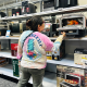 Image: A woman takes a look at the interior of a kitchen appliance