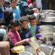 Palestinian kids collect food.