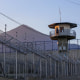 A prison officer stands guard.