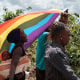 Refugees hold a Pride flag as they march to protest.