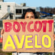 A split composite of a protestor holding a sign that says "boycott Avela", left, and Rachel Maddow