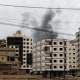 Smoke billows from behind a building