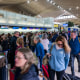 People wait in line for a delayed flight