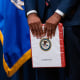 Damian Williams, U.S. attorney for the Southern District of New York, holds a "confidential" binder during a news conference at the Department of Justice in Washington.