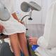A woman in a hospital gown and a doctor in a white lab coat sit across from each other