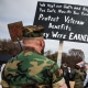 A split composite image of James Parker at a veterans' march holding a sign that reads "We kept our oath and kept you safe, now it's your turn! Protect veteran benefits, they were earned", left, and Jen Psaki.