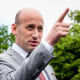 Stephen Miller points while speaking, stands outside