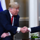 Russian President Vladimir Putin and US President Donald Trump shake hands.