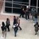 A person is led out during a raid  at Ambiance Apparel in Los Angeles on Friday morning.