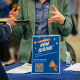 A "Now Hiring" sign at a job and resource fair.