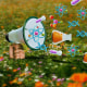 A megaphone pops out from a field of flowers, as atoms, DNA spirals, molecules and more float out from the megaphone.